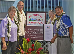 Cheryl Oliver, John Nau, Mayor Tavares and Allen Tom pose next to the Preserve America sign and the proclamation