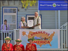 Cheryl Oliver, John Nau, Mayor Tavares and Allen Tom pose next to the Preserve America sign and the proclamation