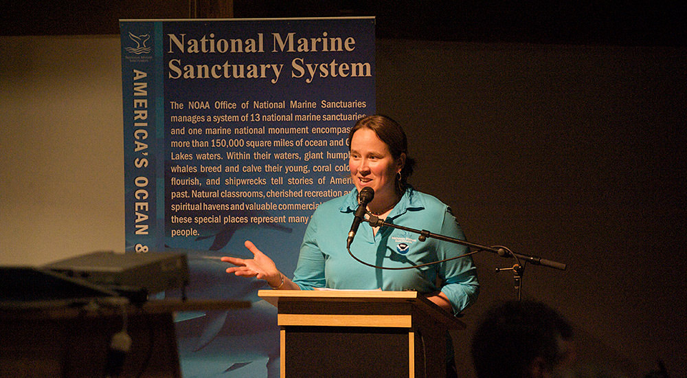 Jenny Stock at a podium giving a presentation