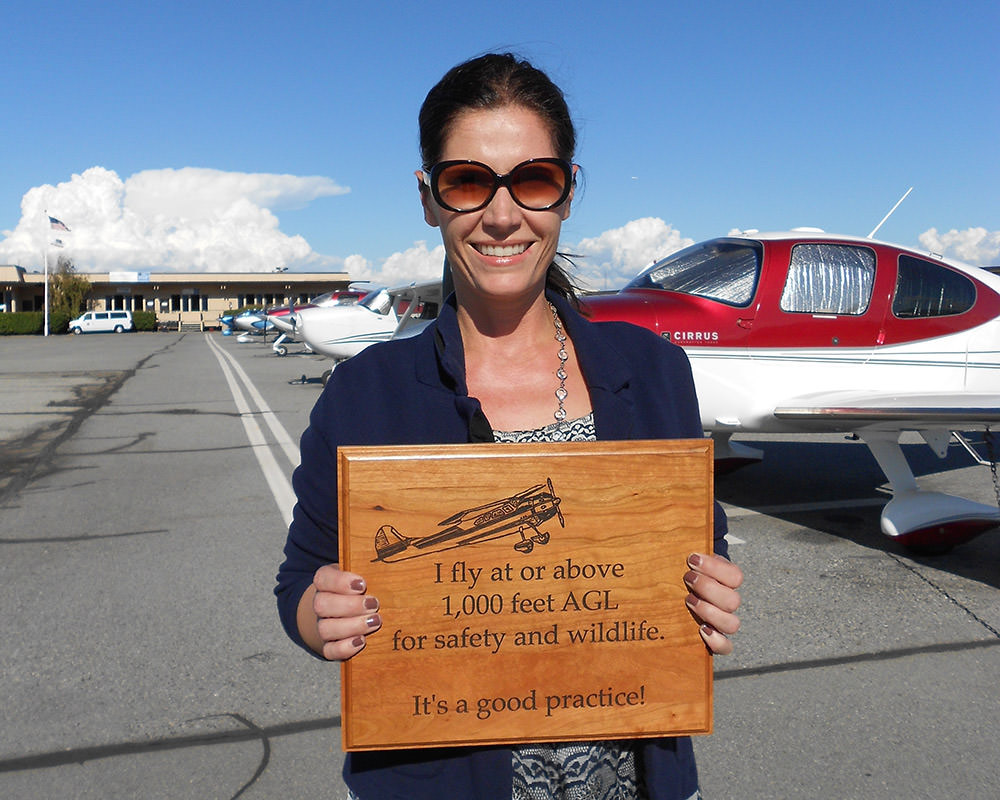 Gretchen Kelly holds a Seabird Protection Network plaque