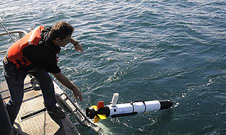 man launching auv into water from the deck