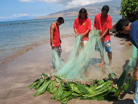 Students of a local canoe club participate in traditional method of gathering fish
