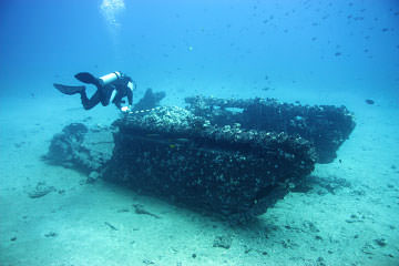 diver examining wreck of a wwii amphibious vessel
