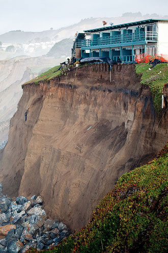 photo of a house on a cliff showing erosion